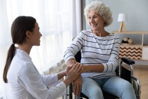 Caregiver taking the hand of a smiling older woman