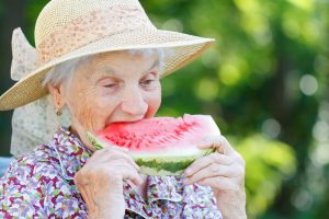 Older woman eating watermelon