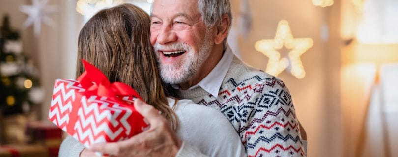 Older man happily hugging a relative in Christmas time.