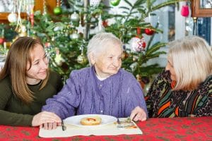 Older woman with dementia celebrating holidays with loved ones.